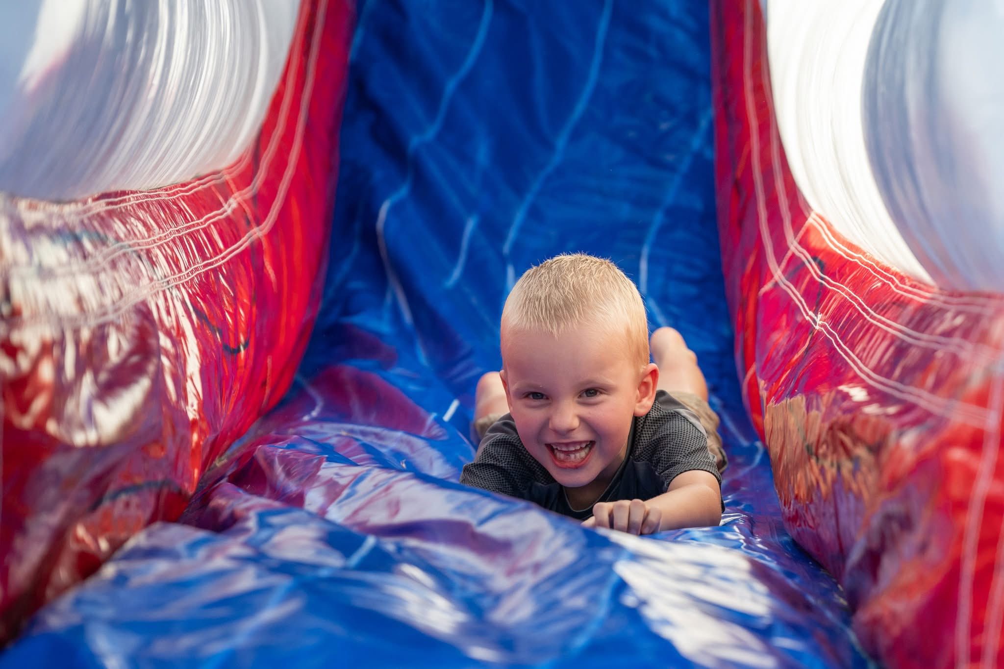 Happy kid on inflatable slide at Boing City Party Rentals event OKC metro El Reno