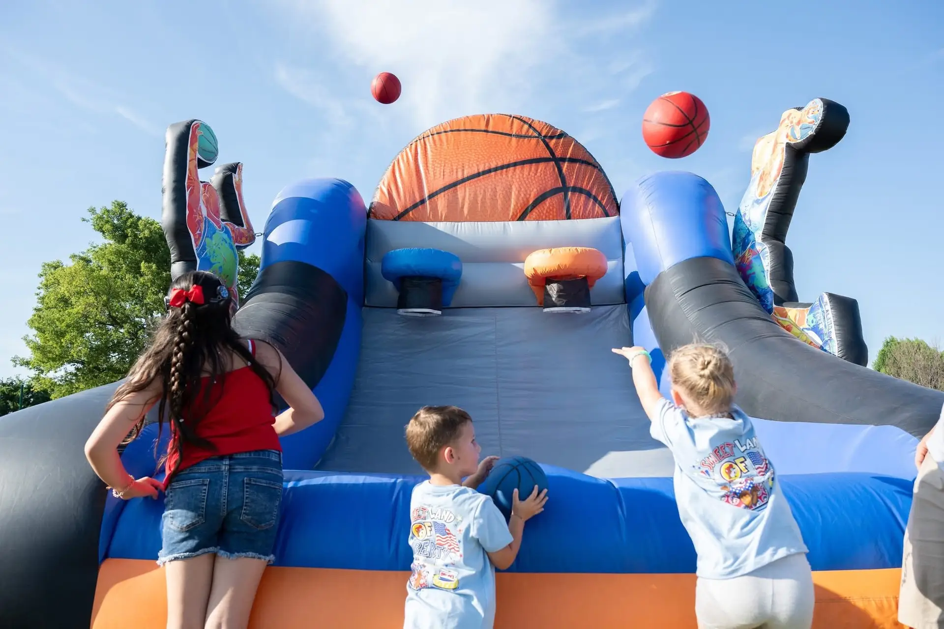 Kids playing inflatable basketball game at Boing City Party Rentals event OKC Edmond